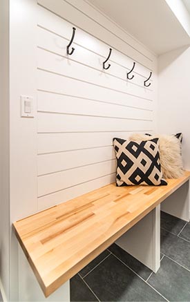 Benches, coat hooks and pillows make this entryway inviting.